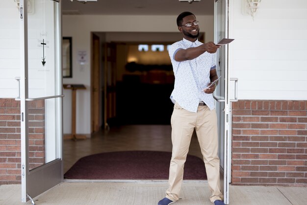 Male standing near the church and giving out pamphlets