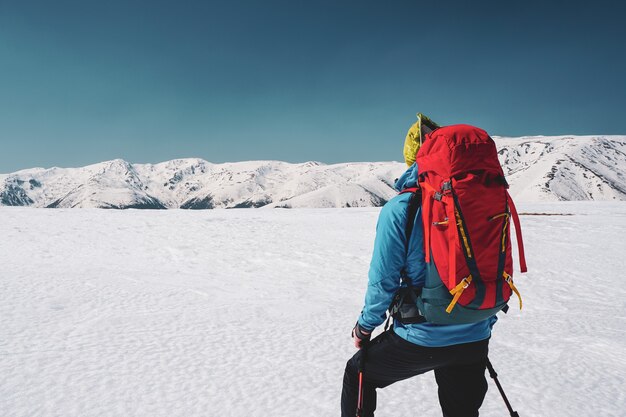 ルーマニアの雪に覆われたカルパティア山脈の息をのむような景色を見つめる男性