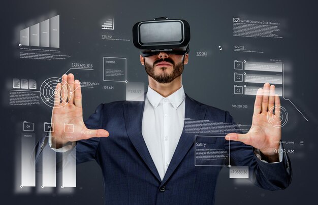 Male in a suit with virtual reality glasses on his head working in virtual financial world.