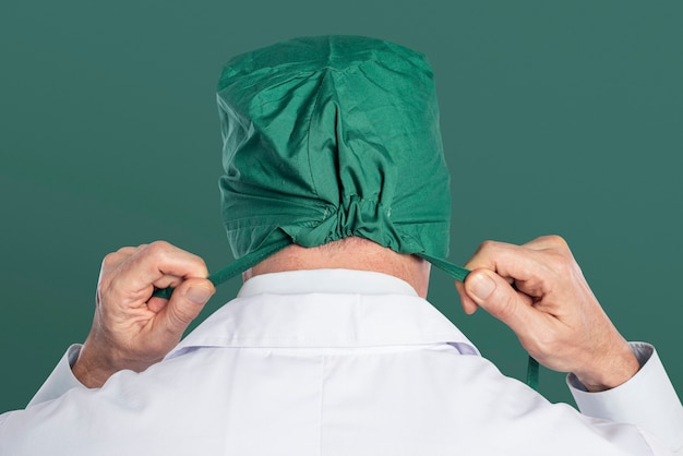 Foto gratuita chirurgo maschio che indossa un berretto chirurgico verde