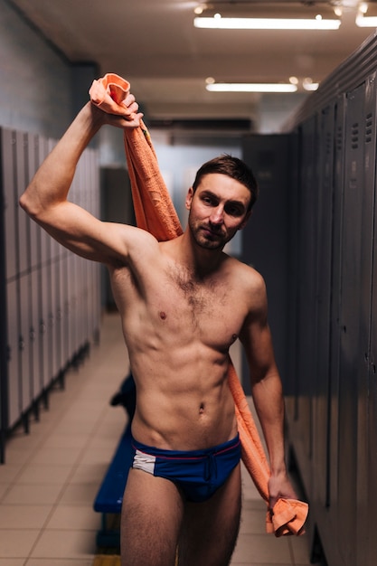 Male swimmer drying with towel