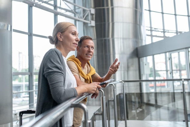 Male talking to his pensive female companion at the airport