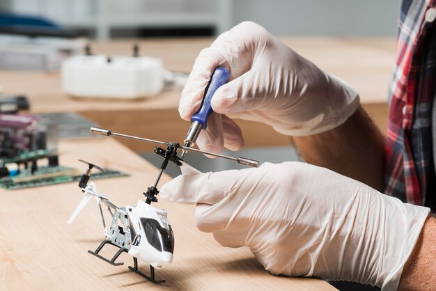 Male technician hand repairing helicopter toy