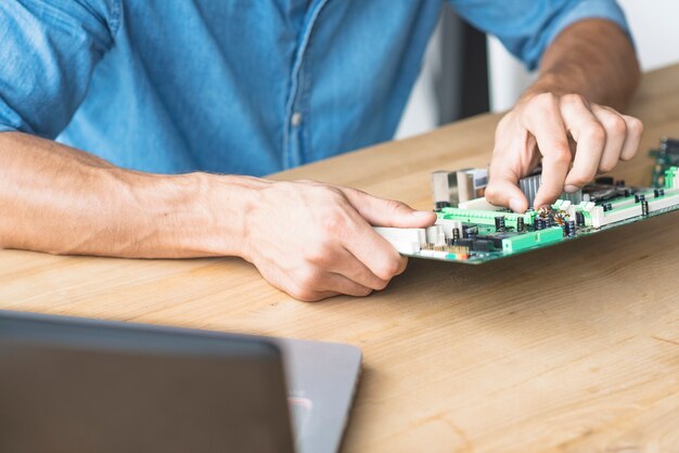 Male technician repairing motherboard at workbench