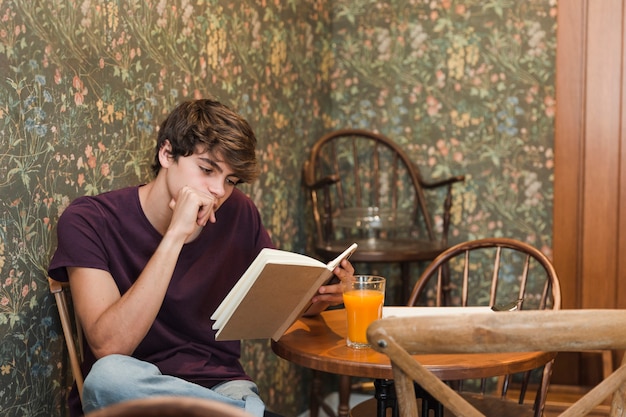 Free photo male teenager reading book and thinking