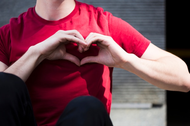 Male teenager showing heart shape with hands 