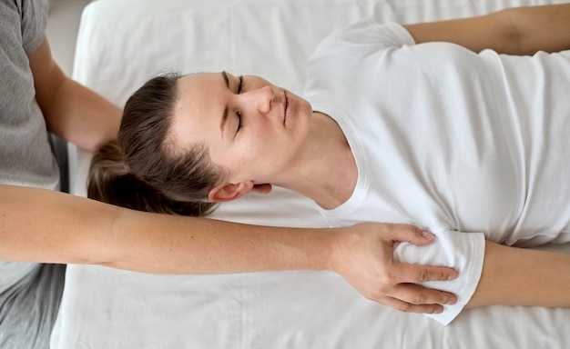 Male therapist undergoing physical therapy with female patient