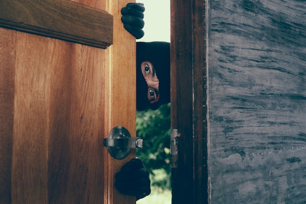 Foto gratuita il ladro maschio apparve alla porta di casa.