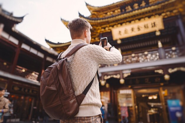 Мужской турист фотографировать пагоду на рынке Yuyuan в Шанхае