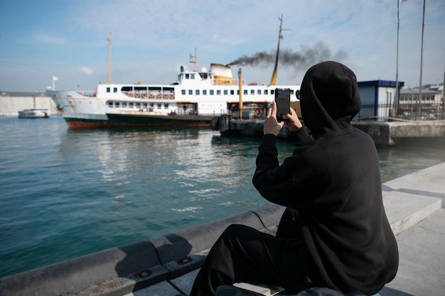 Male tourist taking photos with smartphone during trip