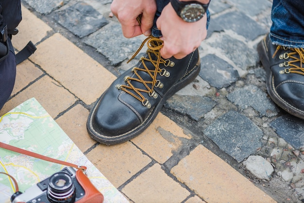 Male tourist tightening shoes