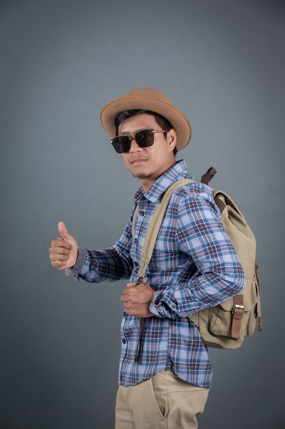 Male tourists backpacking gray background.