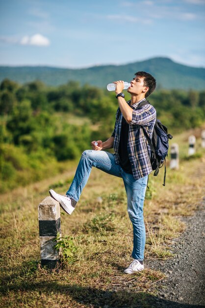 Male tourists drink water and feet stepped on kilometers.