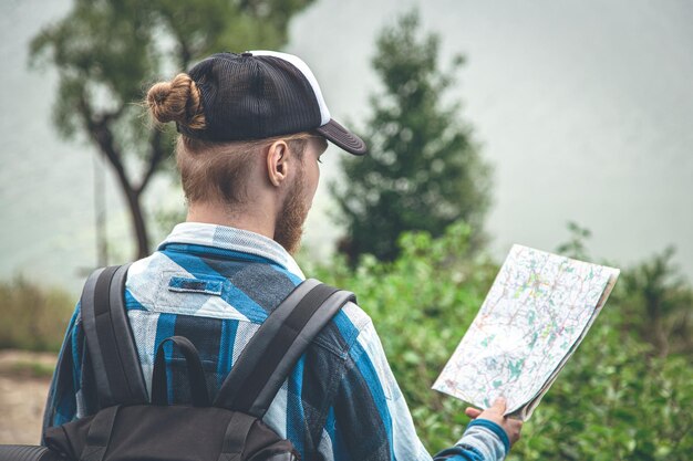 Male traveler looking at the map hiking concept