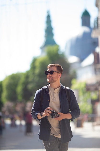 Male traveler with a camera in a local park