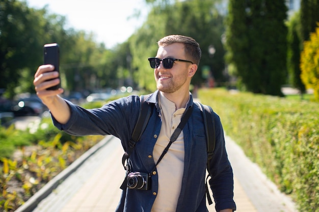 Мужчина-путешественник с фотоаппаратом в местном парке