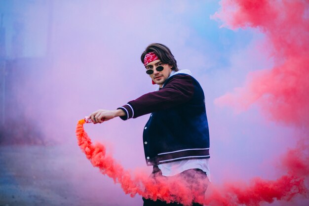 Male urban dancer with colored smoke