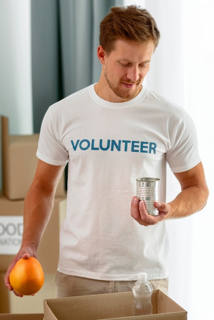 Free photo male volunteer helping with food donations