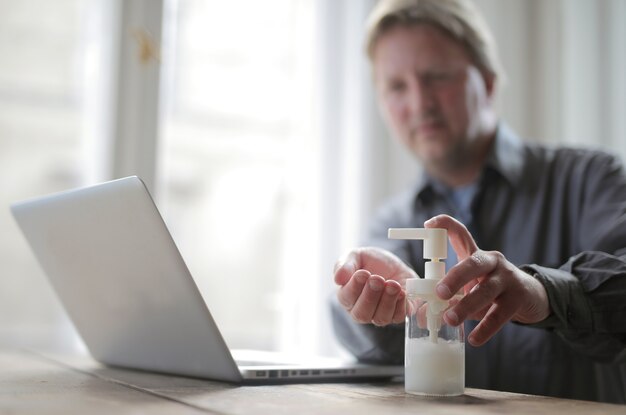 Male washes his hands with soap before working on the computer