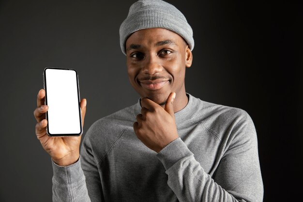 Male wearing cap holding phone