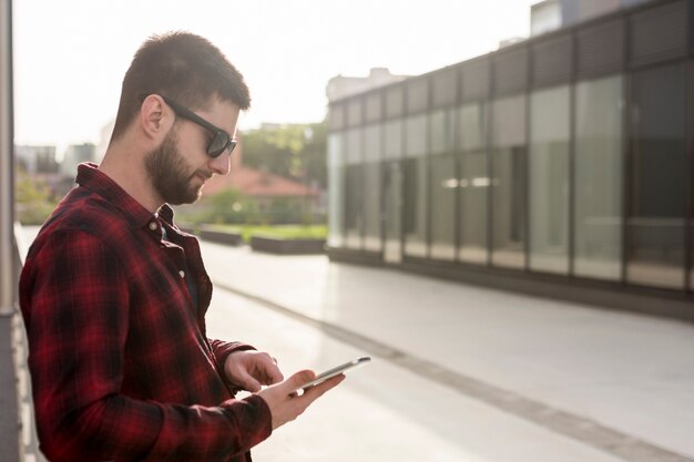 スマートフォンを使用してサングラスをかけた男性