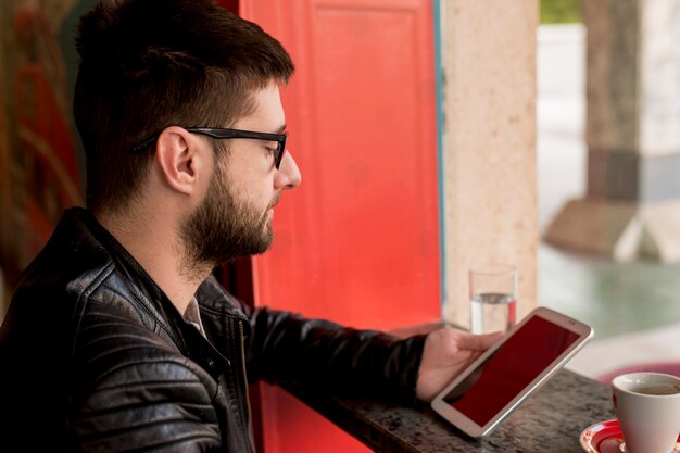 Male with sunglasses using tablet