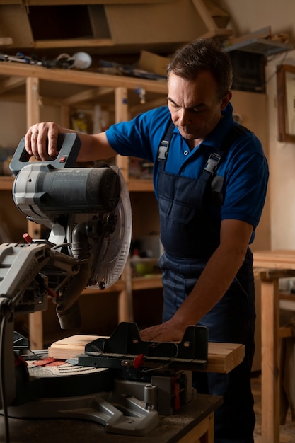 Free photo male wood worker in his shop working with tools and equipment