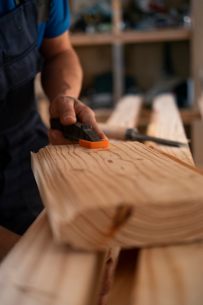 Male wood worker in his shop working with tools and equipment