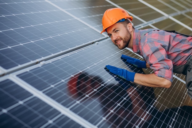 Male worker cleaning solar panels