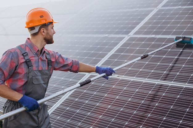 Male worker cleaning solar panels