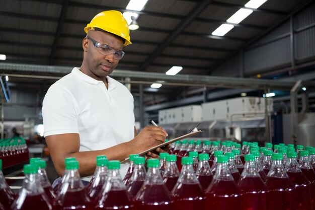 Male worker noting about products in warehouse