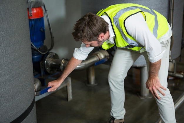 Free photo male worker operating machinery in factory