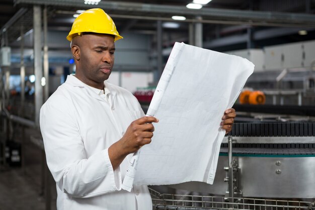 Male worker reading instructions at juice factory