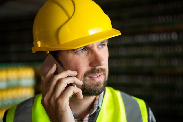 Male worker talking on phone in factory