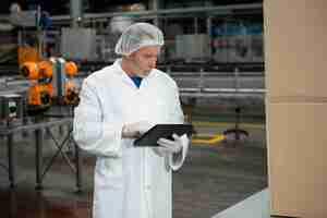 Free photo male worker using digital tablet in cold drink factory