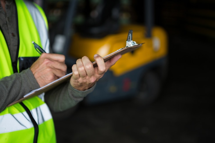 Free Photo male worker writing on clipboard