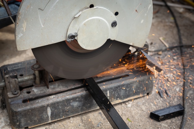 Male workers cut and weld metal with spark.