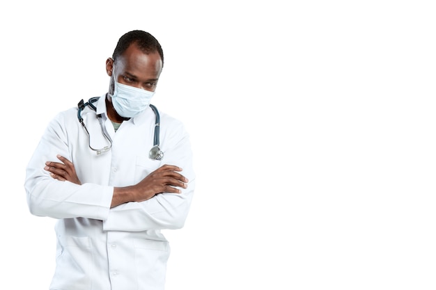 청진 기 및 얼굴 마스크 흰 벽에 고립 된 남성 젊은 의사