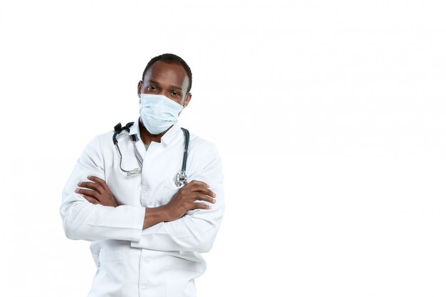 Male young doctor with stethoscope and face mask isolated on white