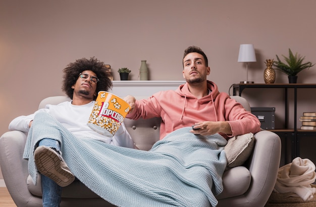 Males eating popcorn and watching movie