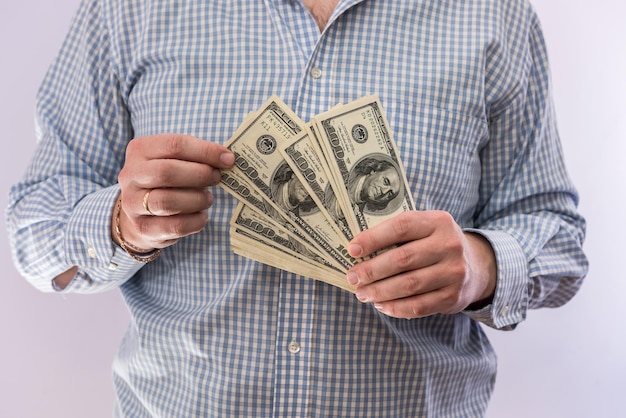 Мужская рука держит изолированную банкноту в 100 долларов. концепция финансов
