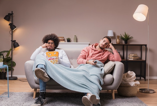 Бесплатное фото Мужчины на диване смотрят фильм