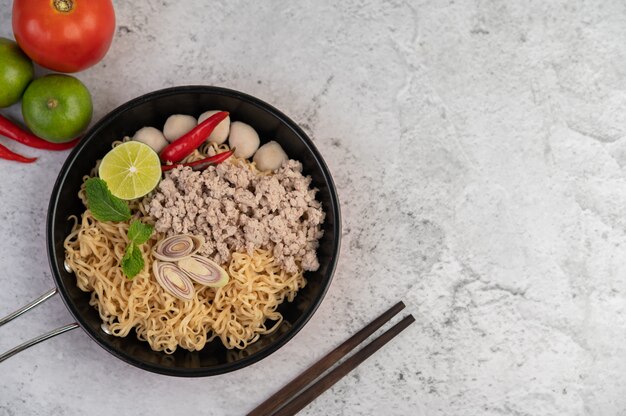 Mama with minced pork in a frying pan.