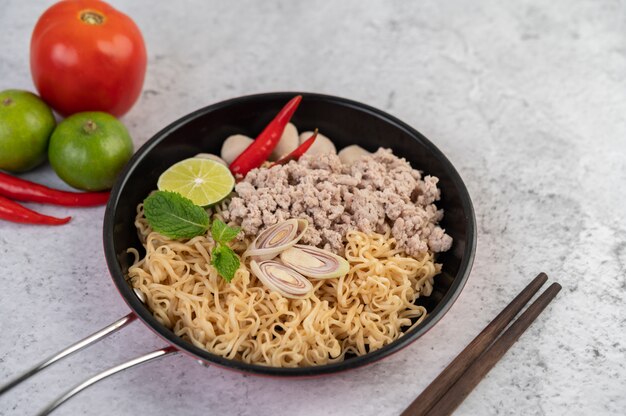 Mama with minced pork in a frying pan.