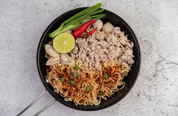 Mama with minced pork in a frying pan.