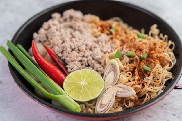 Mama with minced pork in a frying pan.