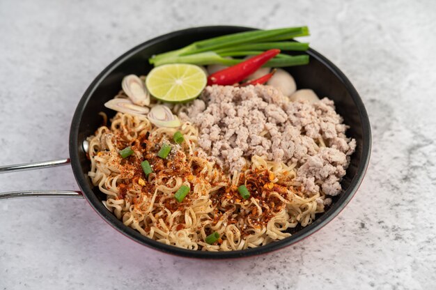 Mama with minced pork in a frying pan.