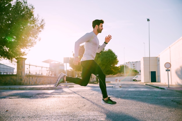 Foto gratuita l'uomo corre attivamente in strada