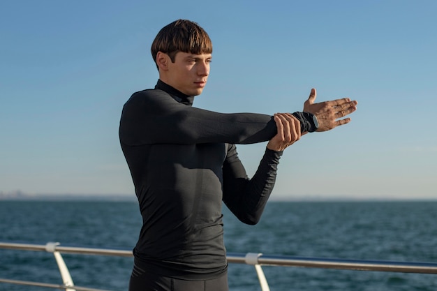 Foto gratuita uomo in abbigliamento sportivo sulla spiaggia