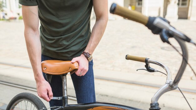 人は自転車の座席を調整する